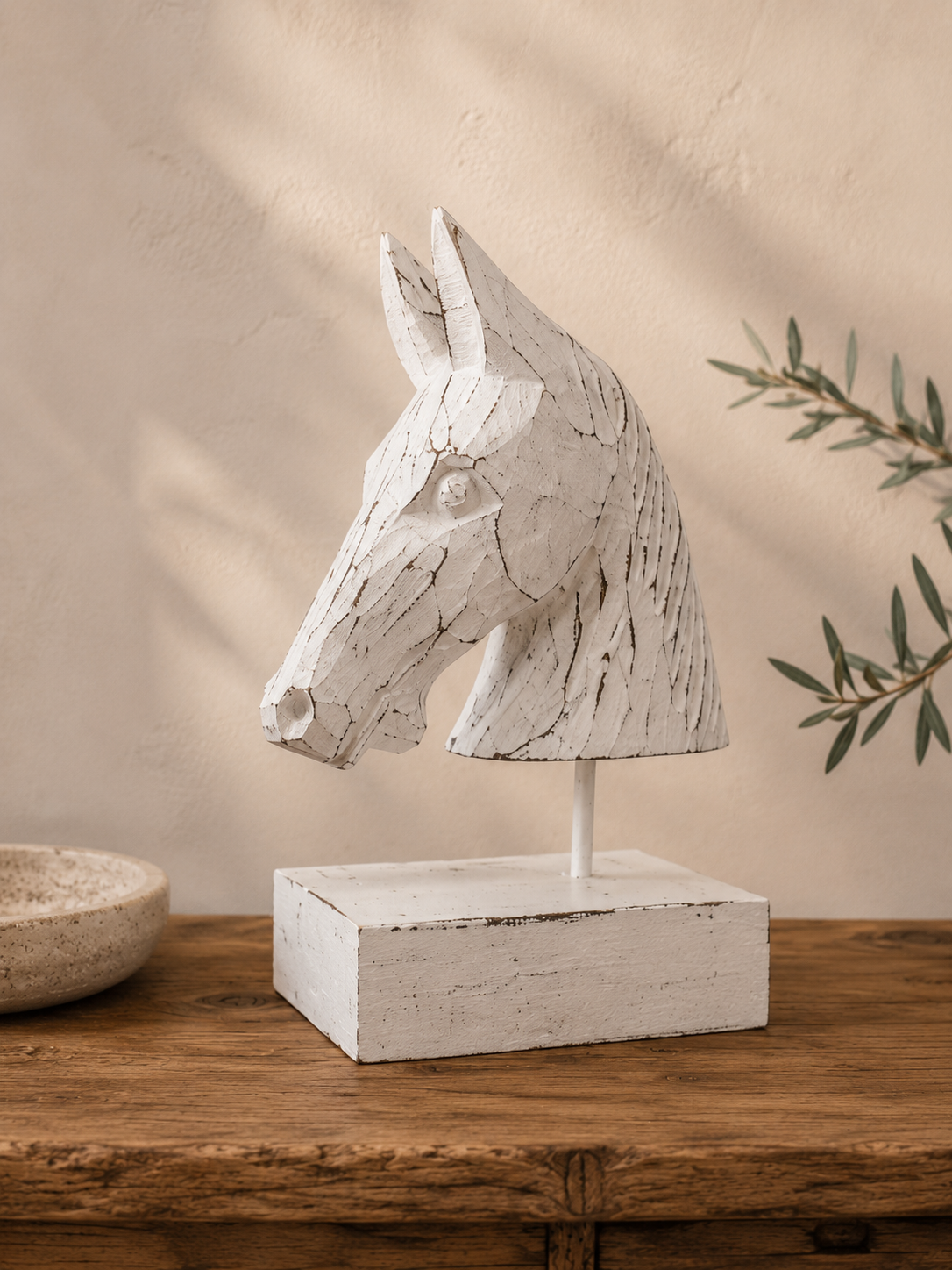 Buste de cheval en bois blanchi dans une décoration intérieure épurée et lumineuse.