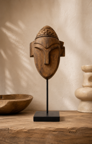 Statuette de guerrier en teck sculpté sur socle noir dans une ambiance ethnique chic et contemporaine.