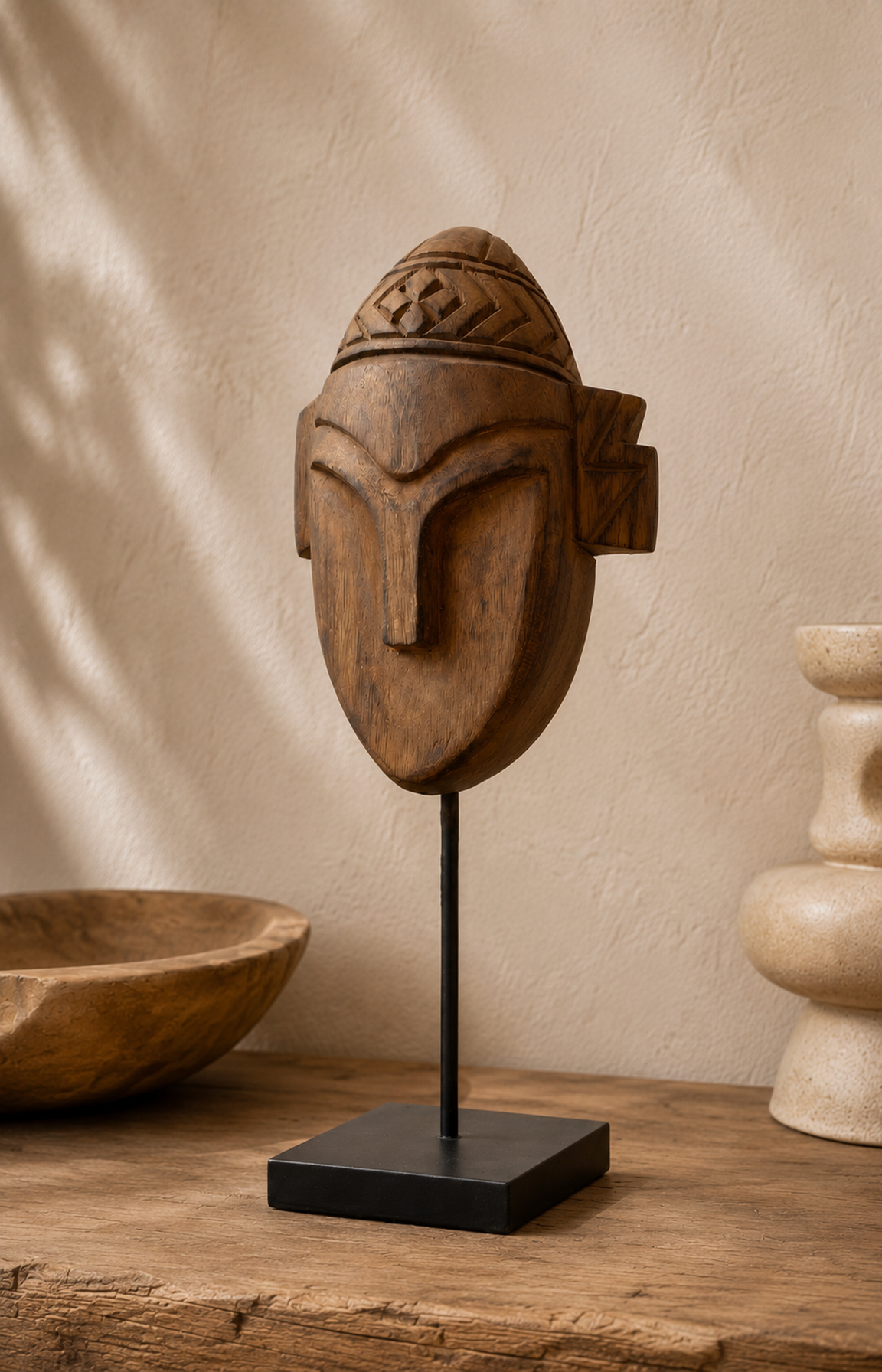 Vue trois-quarts d'une sculpture de guerrier en teck mettant en valeur ses oreilles asymétriques.