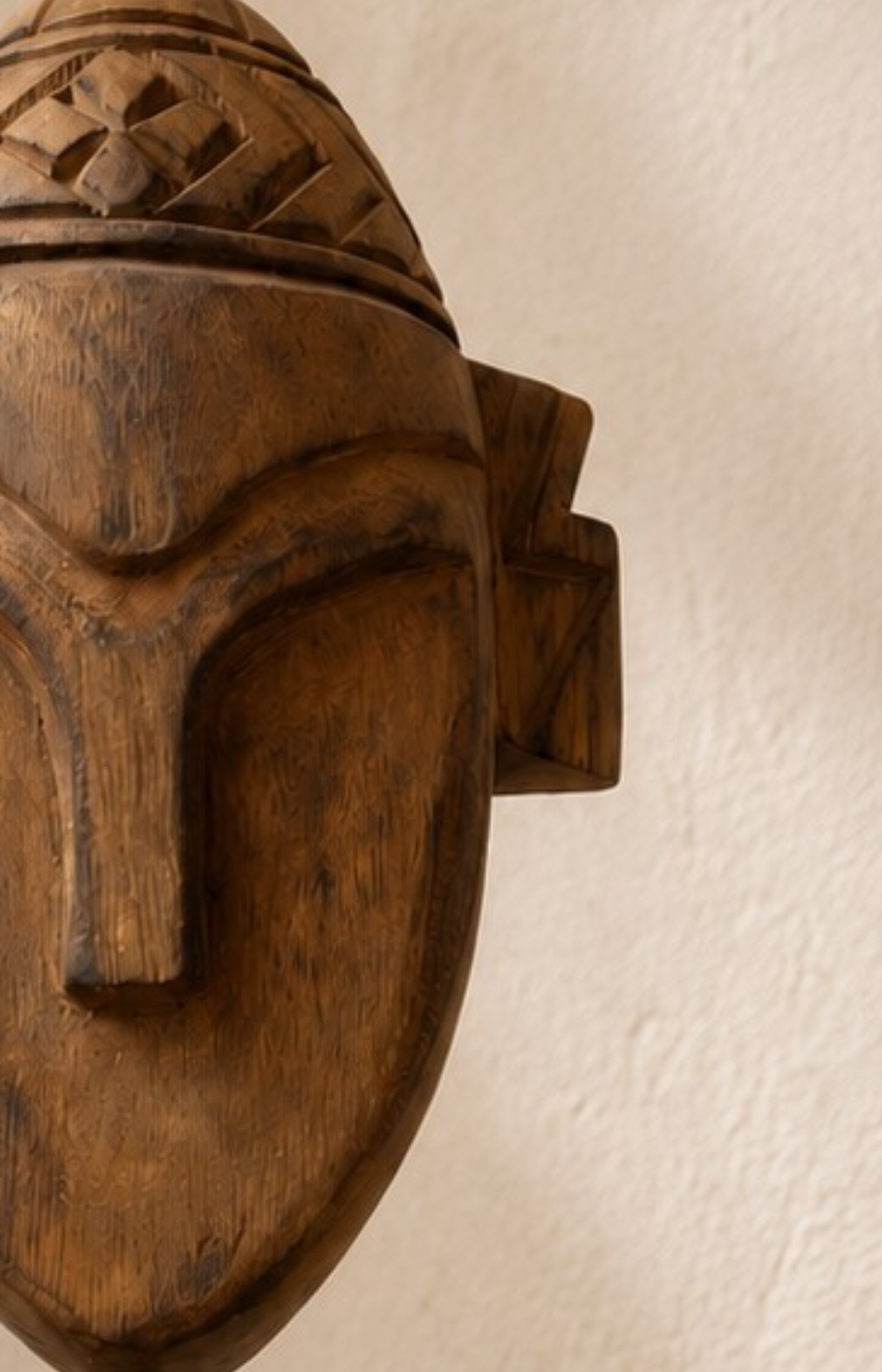 Gros plan sur les motifs géométriques de la coiffe et la finesse du travail artisanal.
