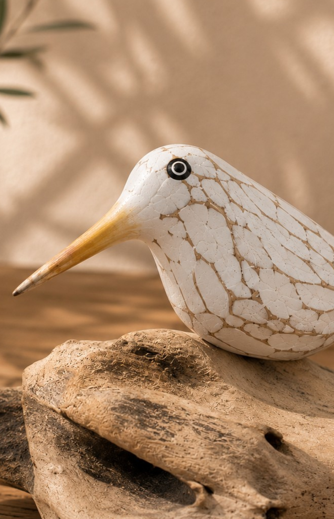 Gros plan sur la patine et le bec jaune d'un oiseau en bois sculpté.
