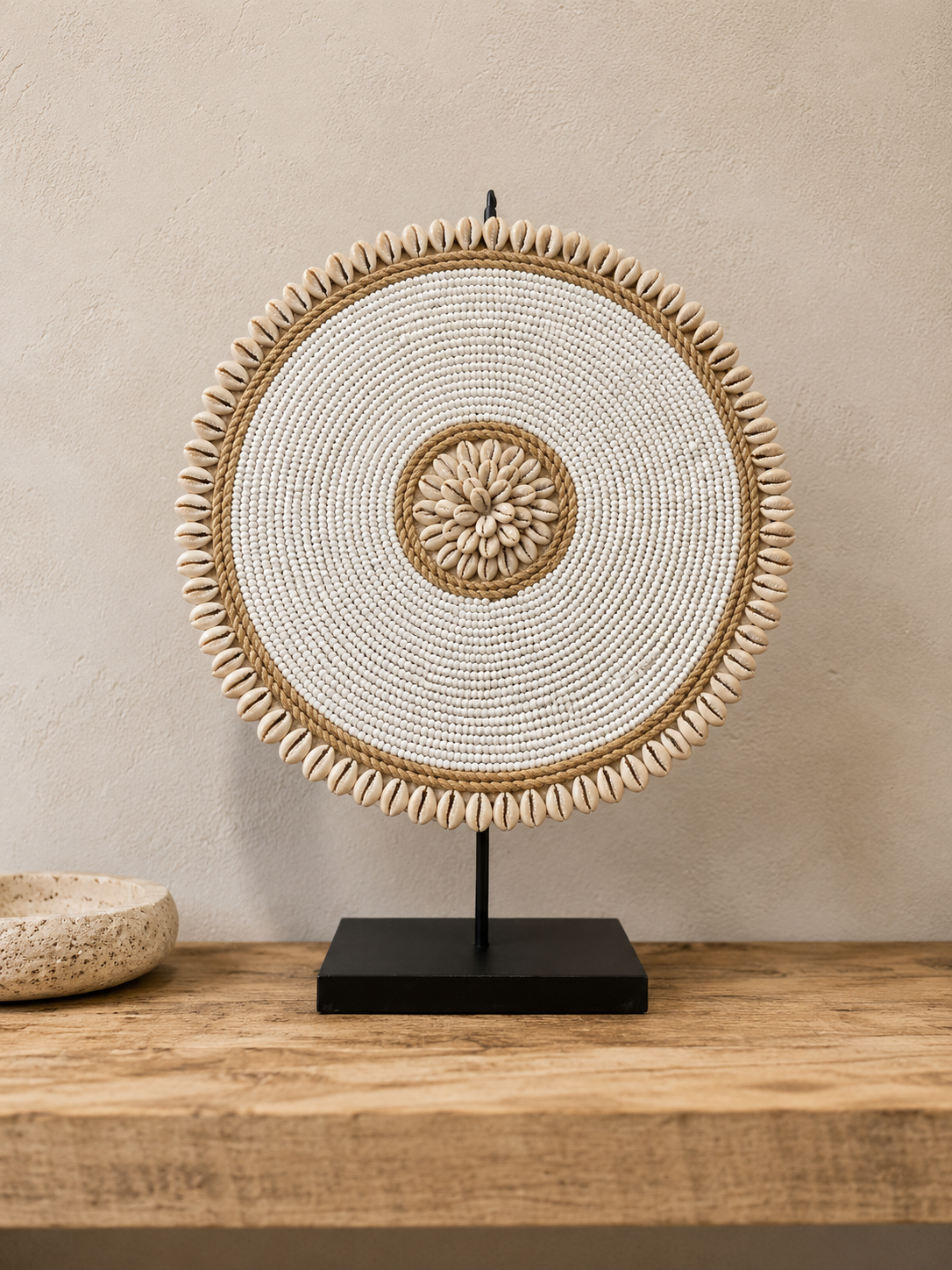 Décoration artisanale en perles et coquillages présentée sur une console en bois naturel.