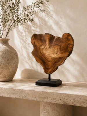 Sculpture en racine de teck sur socle noir présentée sur une console en travertin dans une ambiance bohème chic.
