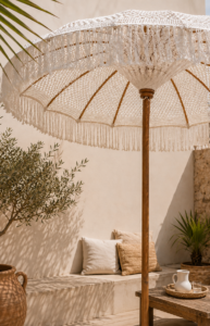 Parasol en macramé blanc à franges installé sur une terrasse bohème chic avec décoration méditerranéenne