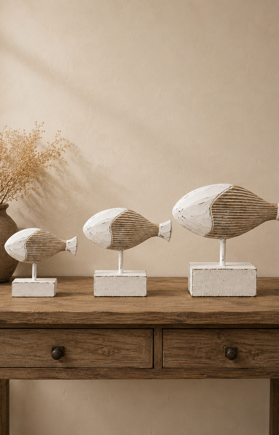 Les trois tailles de sculptures poisson en bois réunies dans une ambiance bord de mer chic.