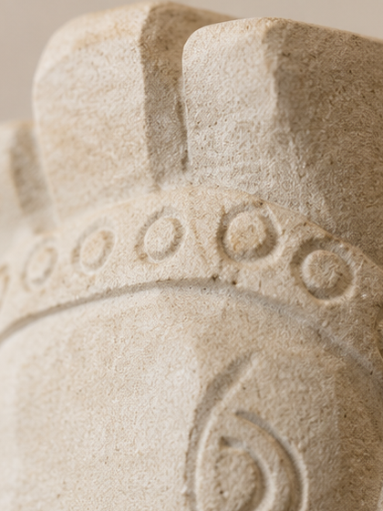Gros plan sur les motifs sculptés et la texture de la pierre calcaire du buste de cheval antique.
