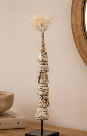 Totem de coquillages présenté sur une console dans une décoration bohème.