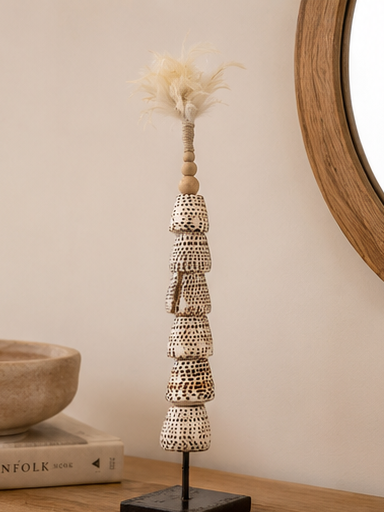 Totem de coquillages présenté sur une console dans une décoration bohème.