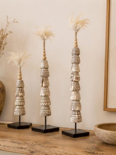 Les trois tailles de totems en coquillages réunies dans une ambiance naturelle et artisanale.