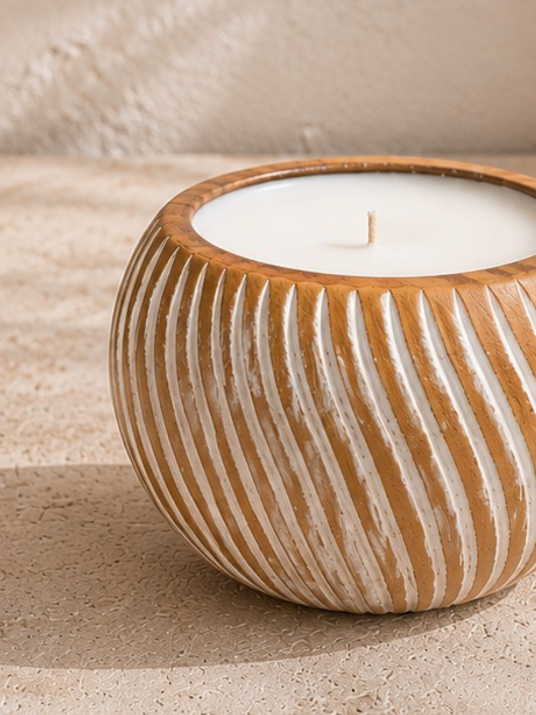Zoom sur les rainures sculptées blanches du contenant en bois massif de la bougie artisanale.