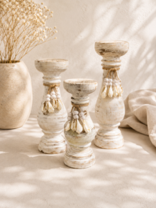 Ensemble de bougeoirs en bois blanc patiné ornés de coquillages naturels dans une décoration bohème chic aux inspirations bord de mer.