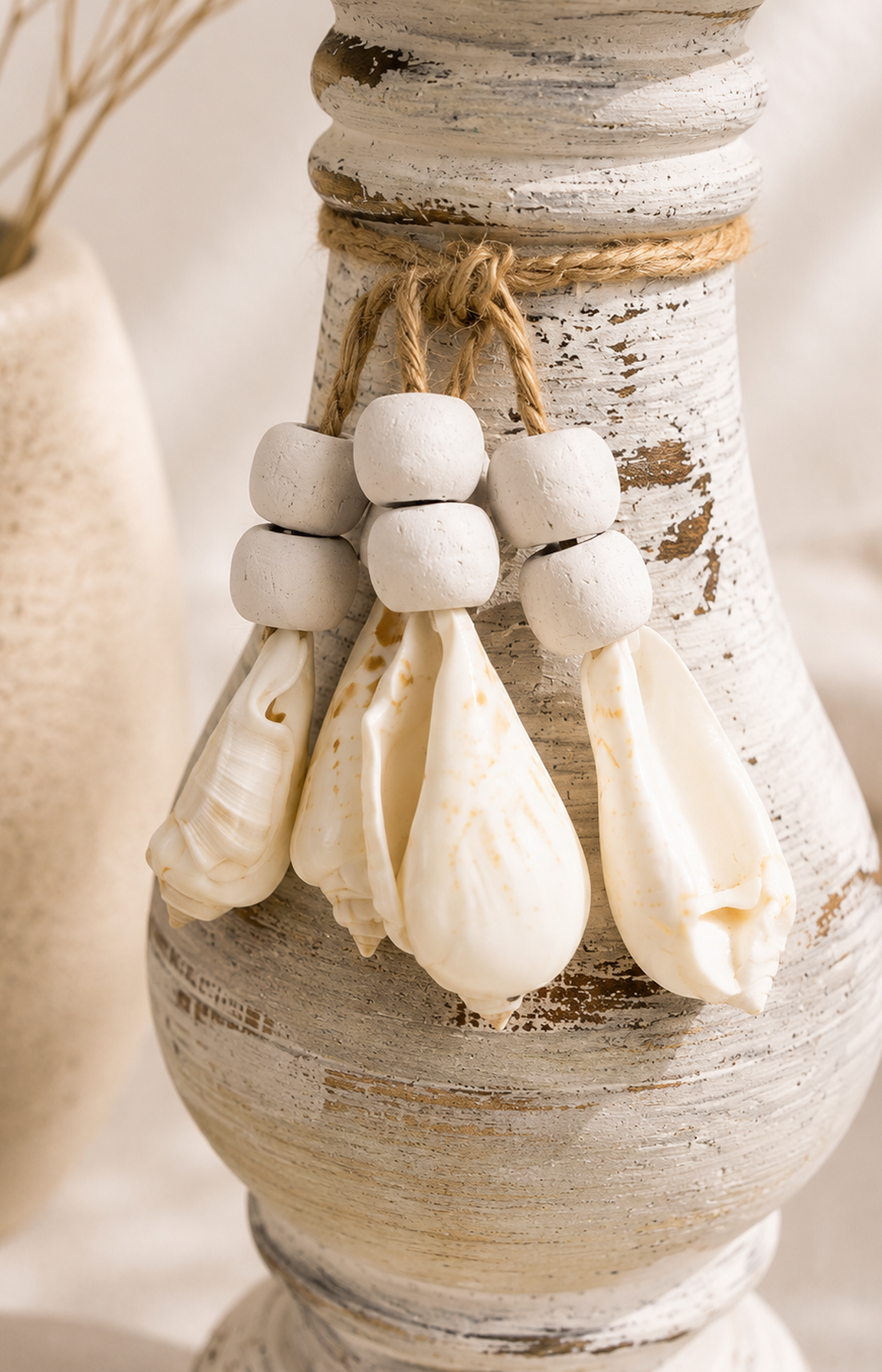 Gros plan sur les coquillages suspendus du bougeoir artisanal esprit bord de mer.