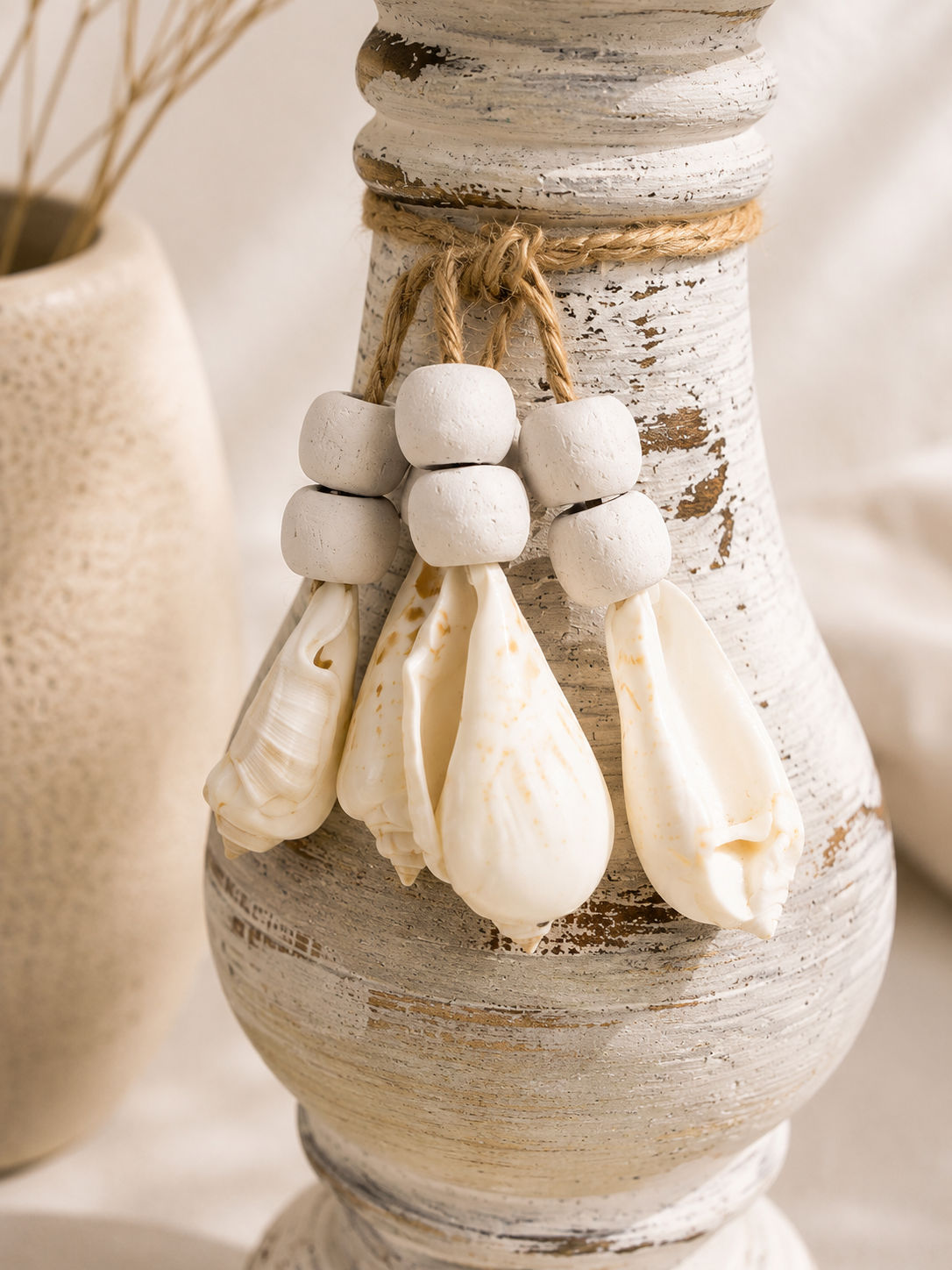 Gros plan sur les coquillages suspendus du bougeoir artisanal esprit bord de mer.