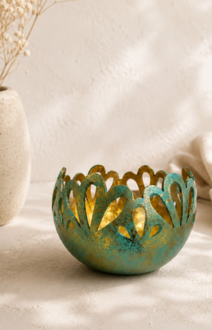 Photophore artisanal en noix de coco sculptée à patine turquoise et dorée dans une décoration bohème minimaliste aux tons naturels.