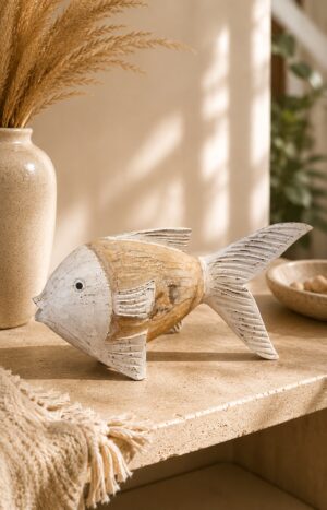 Poisson décoratif en bois sculpté blanc et beige posé sur travertin dans une décoration bohème