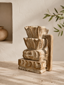 Bougeoir indien sculpté en bois patiné dans une décoration bohème minimaliste aux tons naturels.