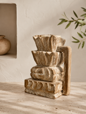 Bougeoir indien sculpté en bois patiné dans une décoration bohème minimaliste aux tons naturels.