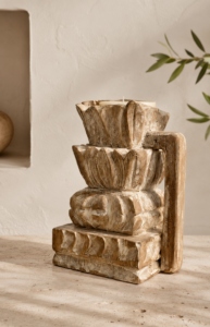 Bougeoir indien sculpté en bois patiné dans une décoration bohème minimaliste aux tons naturels.