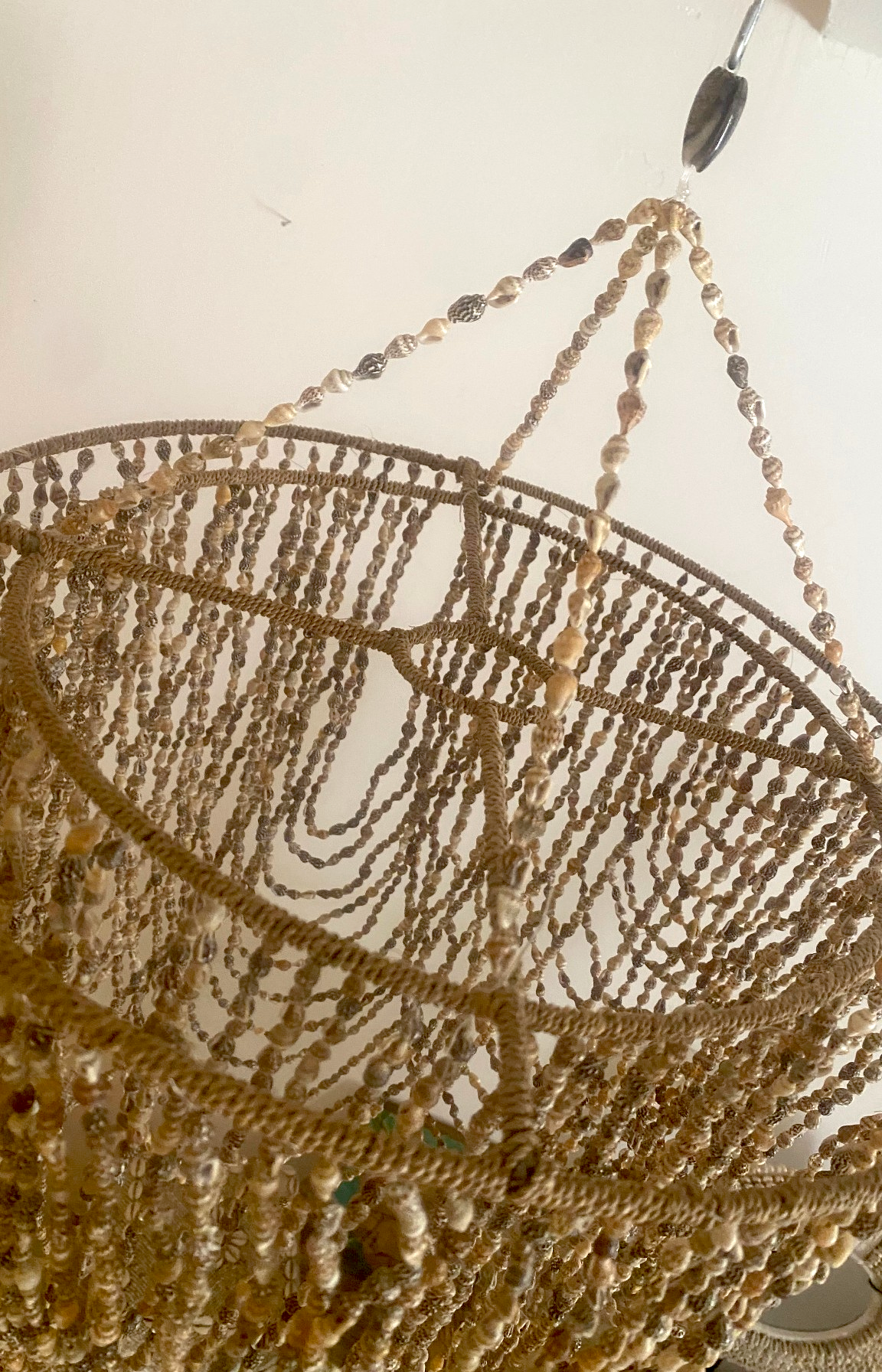 vue rapprochée d'un lustre bohème en coquillages naturels avec finitions artisanales