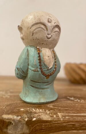 statue moine souriant en bois posé sur une console
