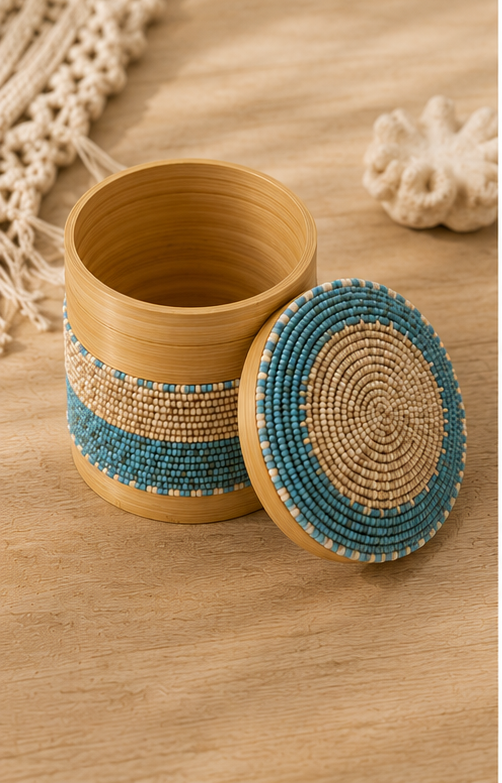Boîte décorative cylindrique en bambou ornée de perles de verre bleu turquoise et beige, présentée dans une ambiance bohème chic.