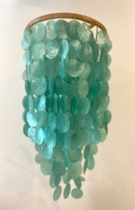 Lustre en nacre vert lagon suspendu sur structure en rotin naturel