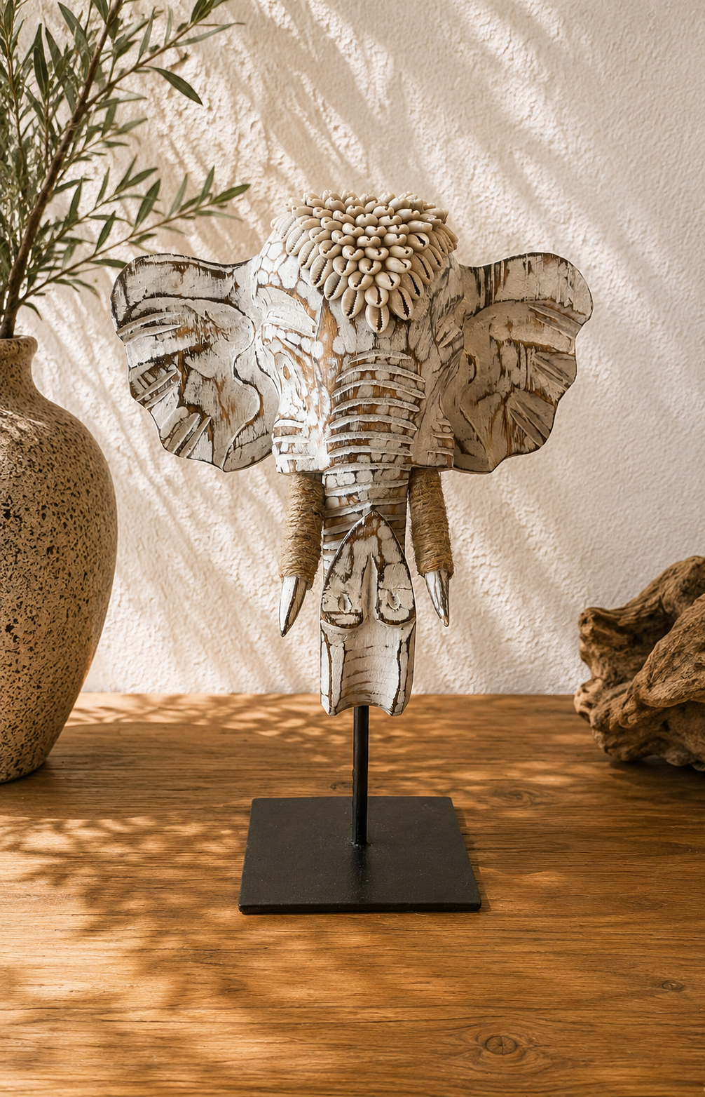 Statue éléphant bois blanc et coquillages sur socle en acier noir dans une décoration bohème chic