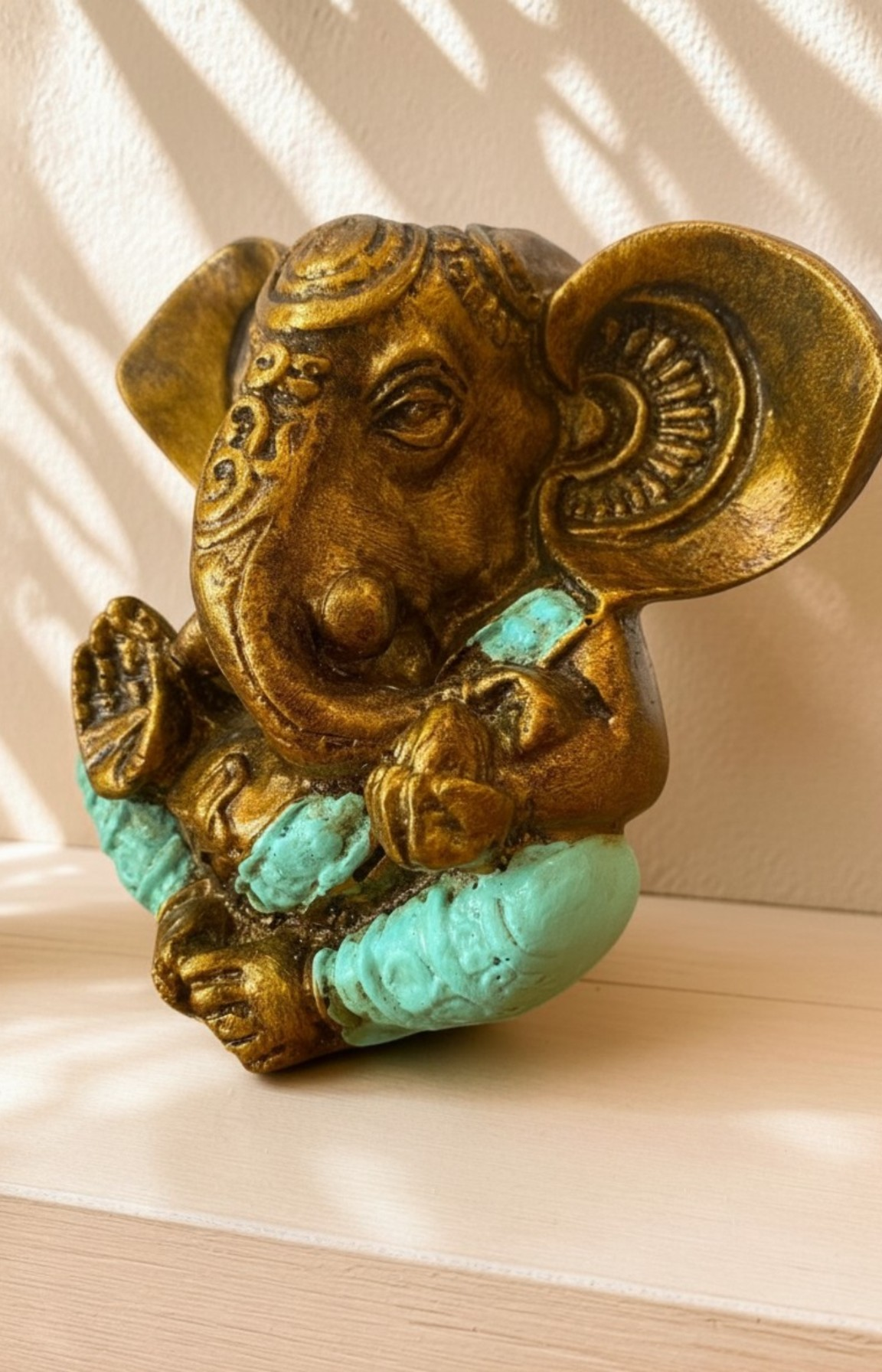 Détail des finitions dorées d'une statue Ganesh en résine turquoise