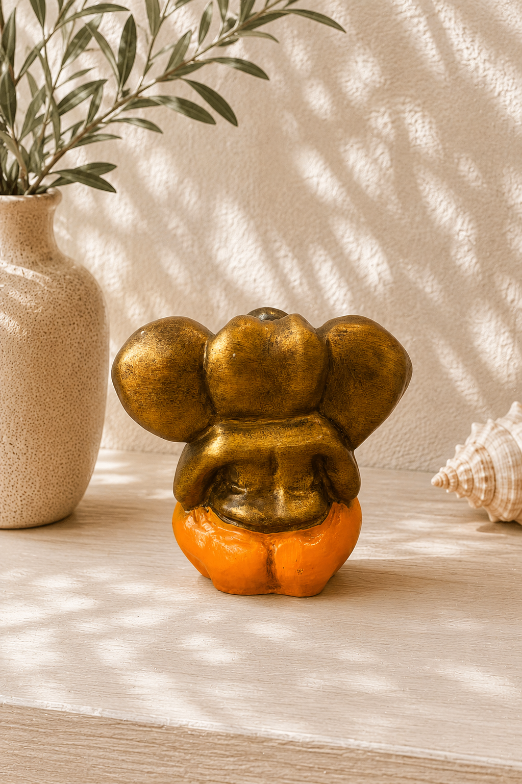 Dos d'une statue Ganesh en résine orange décoration spirituelle