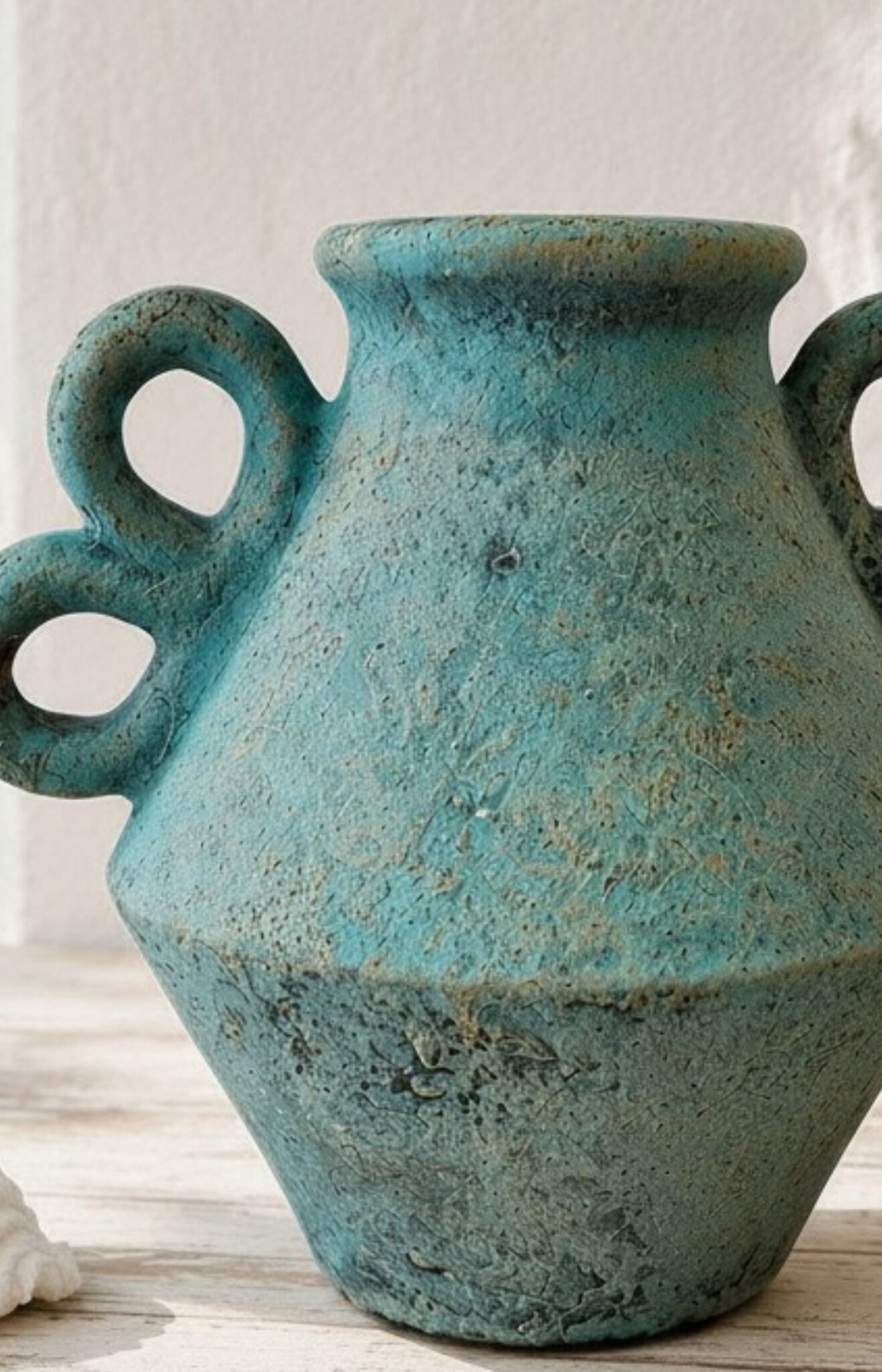 Détail de la texture patinée d'un vase en terre cuite turquoise artisanal