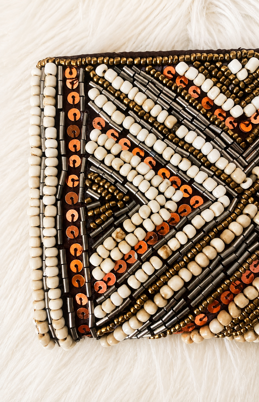 Détail des perles et sequins d’un porte-monnaie brodé aux motifs géométriques