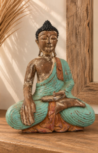 Bouddha assis en bois patiné turquoise dans une ambiance bohème zen