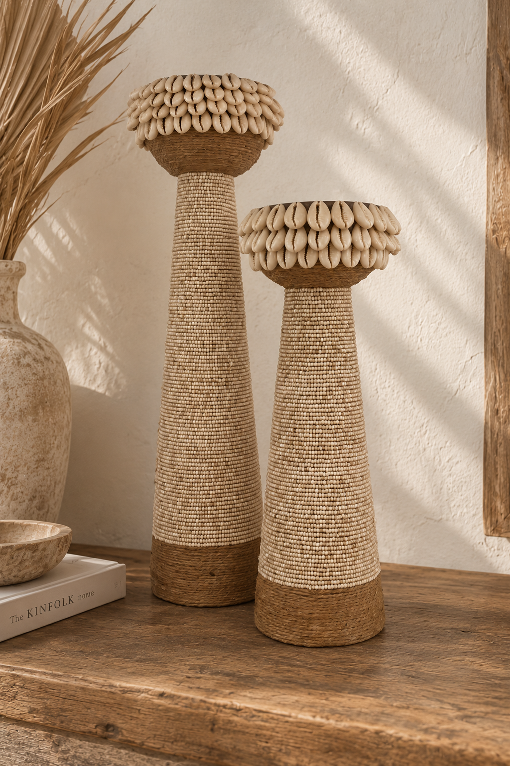 Bougeoirs en bois recouverts de perles beiges, corde et coquillages dans une ambiance bohème naturelle